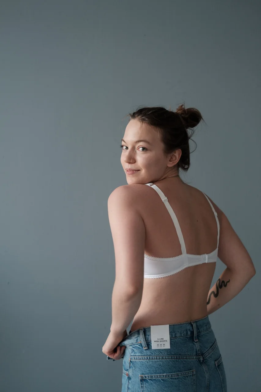 Modelo de costas usando sutiã branco, em fotografia de estúdio